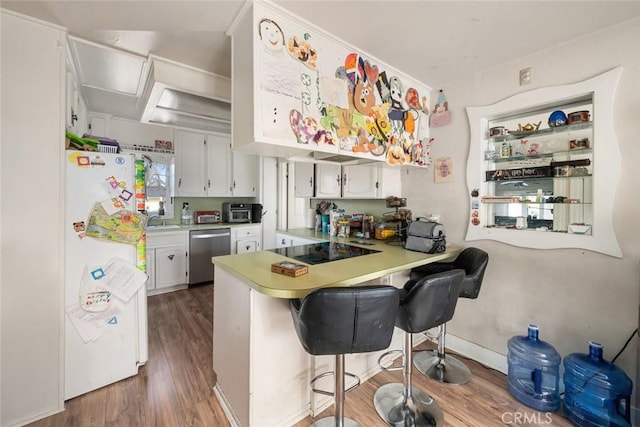 kitchen with a peninsula, freestanding refrigerator, dark wood-type flooring, dishwasher, and black electric cooktop