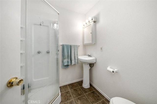 full bathroom with baseboards, toilet, a stall shower, and tile patterned flooring