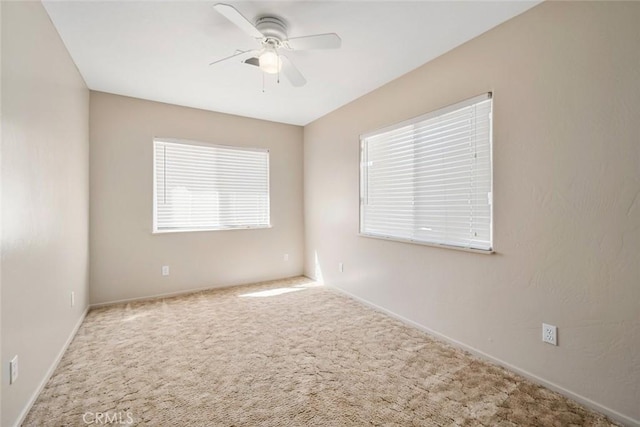 carpeted spare room featuring a ceiling fan