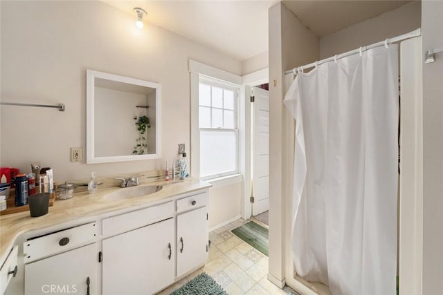 bathroom with curtained shower, vanity, and baseboards