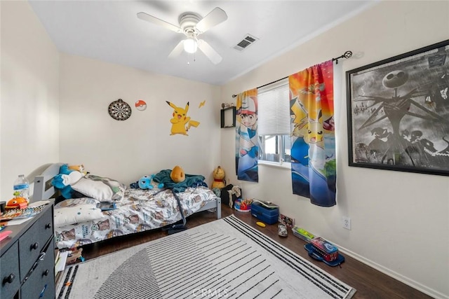 bedroom featuring a ceiling fan, wood finished floors, visible vents, and baseboards