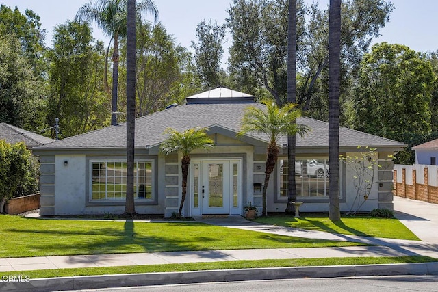 ranch-style house featuring a shingled roof, a front lawn, fence, and stucco siding