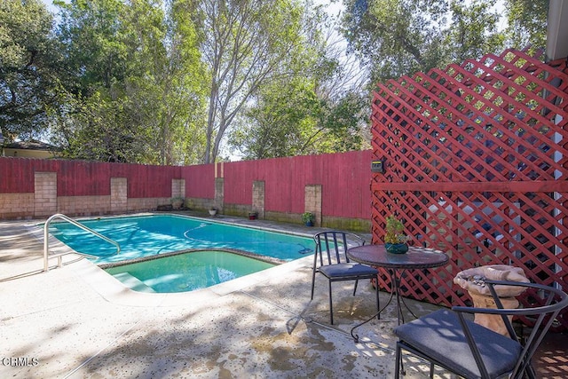 view of pool with a patio, a pool with connected hot tub, and fence