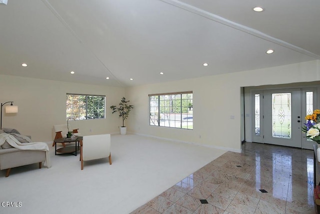 living room featuring vaulted ceiling, recessed lighting, and baseboards