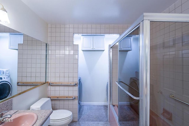 full bath with toilet, a stall shower, washer / clothes dryer, tile walls, and baseboards