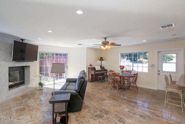 living room with ceiling fan, recessed lighting, visible vents, and a premium fireplace