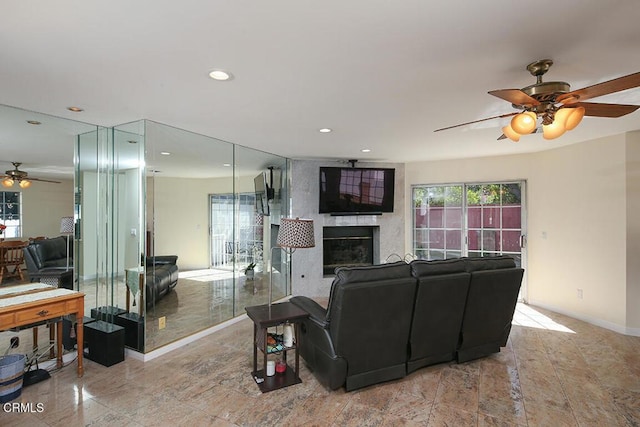 living area with recessed lighting, a fireplace, baseboards, and a ceiling fan