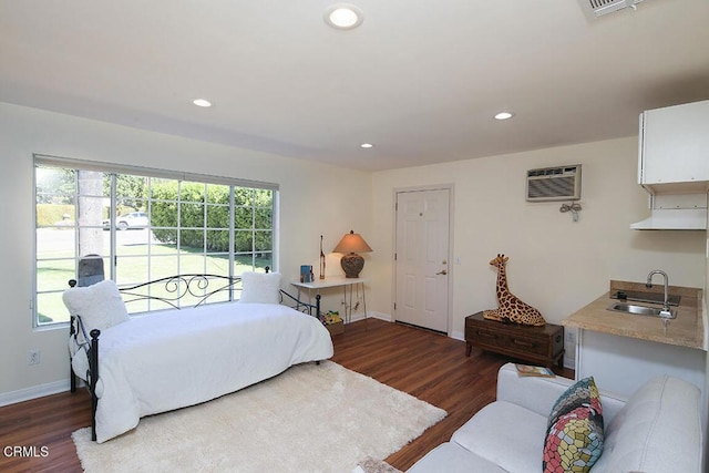 bedroom featuring wood finished floors, baseboards, recessed lighting, a sink, and a wall mounted air conditioner