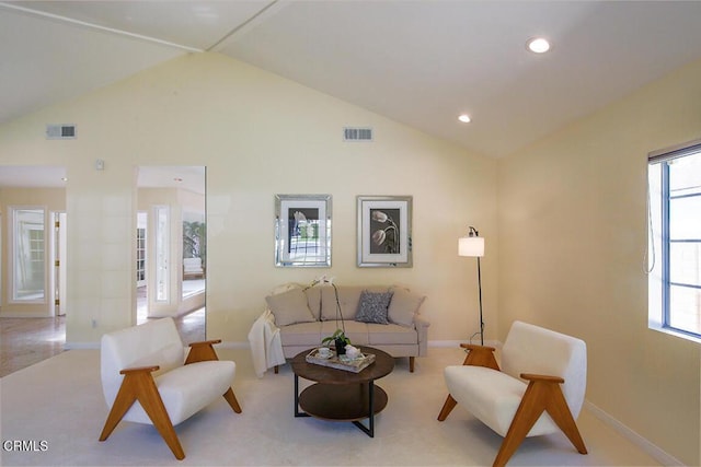 carpeted living area with lofted ceiling, plenty of natural light, and visible vents