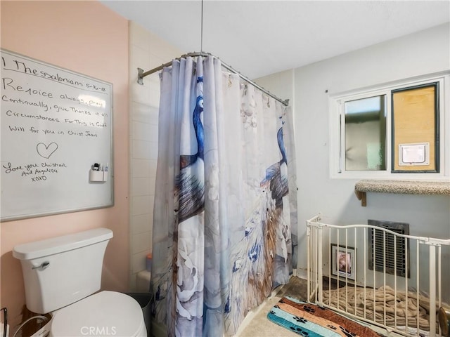 bathroom featuring curtained shower and toilet