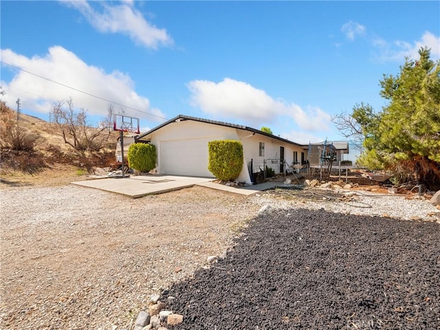 view of front of home with an attached garage, driveway, and stucco siding