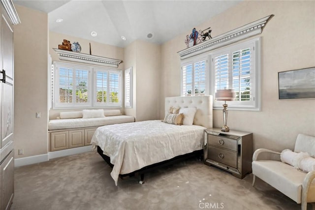 bedroom with baseboards, light colored carpet, and vaulted ceiling