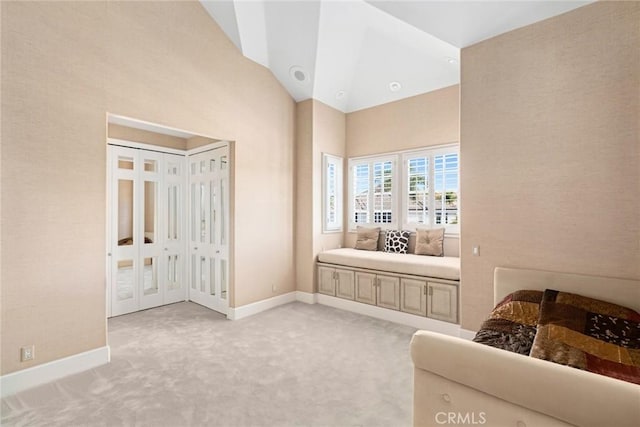 bedroom with high vaulted ceiling, baseboards, and light carpet