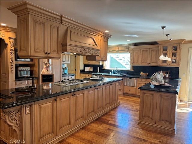 kitchen featuring a warming drawer, custom range hood, a sink, a center island, and light wood-style floors