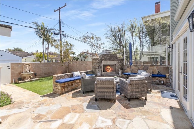 view of patio featuring an outdoor living space with a fireplace and a fenced backyard