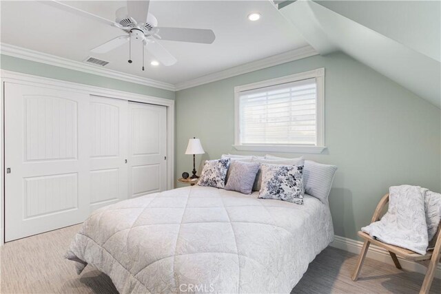 bedroom with visible vents, lofted ceiling, ornamental molding, a closet, and baseboards