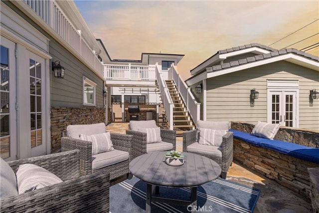 view of patio / terrace with outdoor lounge area, stairway, and french doors