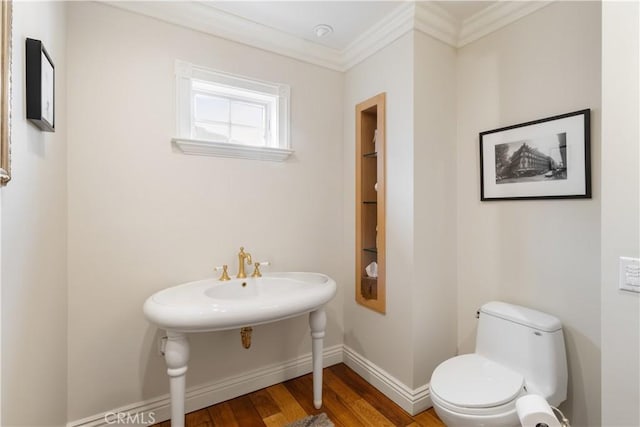 bathroom featuring crown molding, toilet, wood finished floors, and baseboards