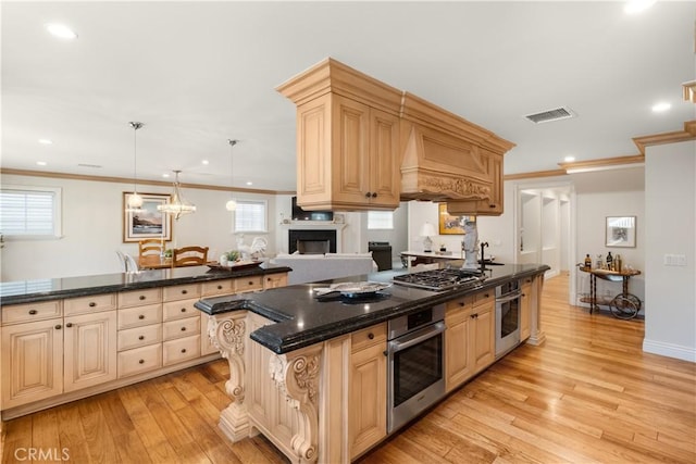kitchen featuring visible vents, custom exhaust hood, cream cabinetry, light wood-style floors, and appliances with stainless steel finishes