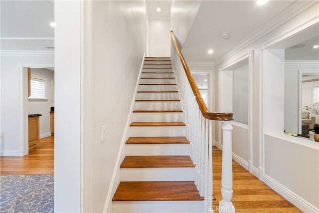 staircase featuring recessed lighting, baseboards, wood finished floors, and crown molding