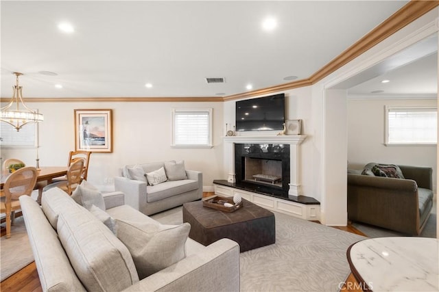 living area featuring recessed lighting, a fireplace, visible vents, and light wood-type flooring