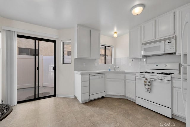 kitchen featuring backsplash, light countertops, white appliances, white cabinetry, and a sink