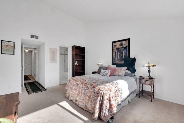 carpeted bedroom with visible vents and high vaulted ceiling