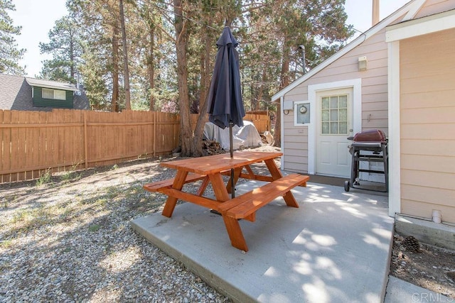 view of patio featuring outdoor dining space, grilling area, and fence