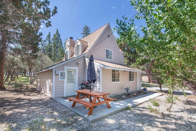 back of house featuring a patio and a chimney