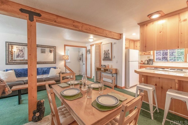 dining room with recessed lighting, beam ceiling, and light colored carpet