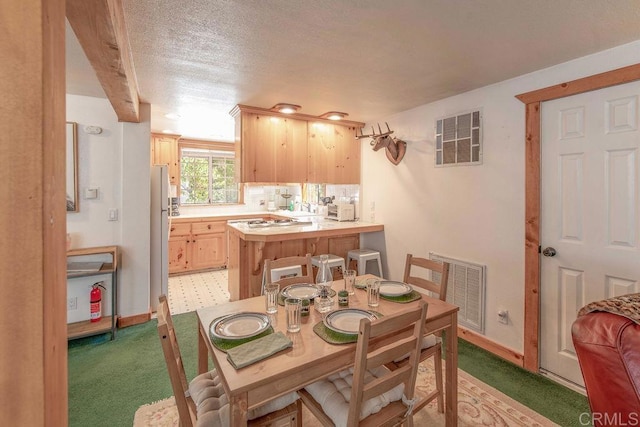 dining area with visible vents, baseboards, and light colored carpet