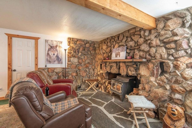 living room with beamed ceiling, a textured ceiling, and a wood stove