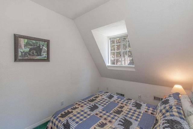 bedroom with lofted ceiling and visible vents