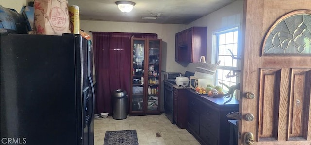 kitchen featuring light floors and black refrigerator with ice dispenser