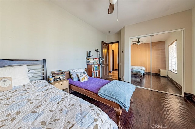 bedroom with wood finished floors, baseboards, ceiling fan, vaulted ceiling, and a closet