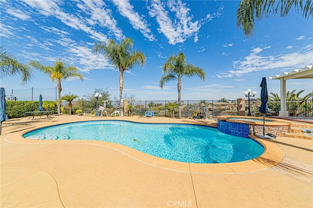 view of pool featuring a pool with connected hot tub, a patio, and fence