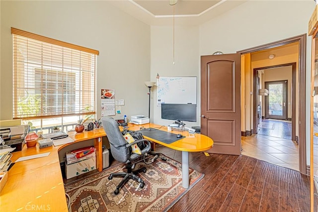 office space featuring plenty of natural light, a high ceiling, and wood finished floors