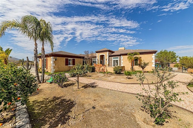 view of front facade featuring stucco siding and fence