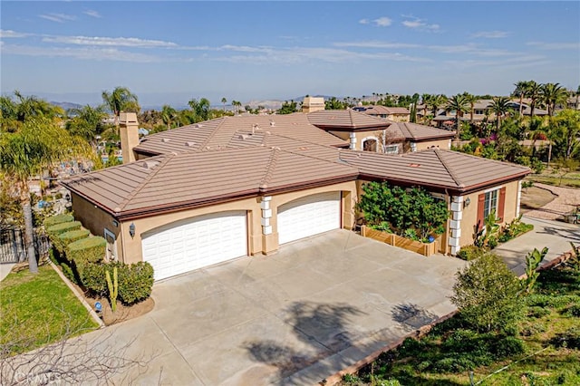 view of front facade featuring fence, an attached garage, stucco siding, concrete driveway, and a tiled roof