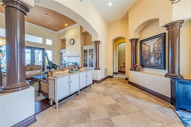 kitchen featuring baseboards, a high ceiling, and ornate columns