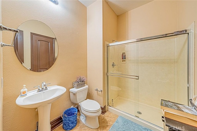 bathroom with a shower stall, toilet, and tile patterned floors