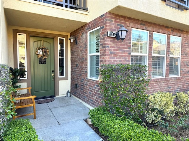 entrance to property with stucco siding and brick siding