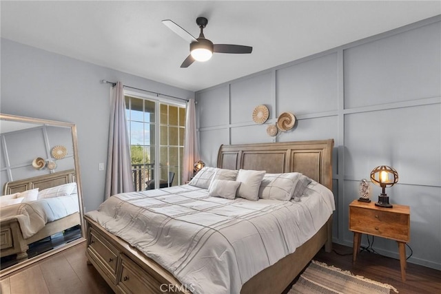 bedroom featuring ceiling fan, dark wood-style floors, and a decorative wall