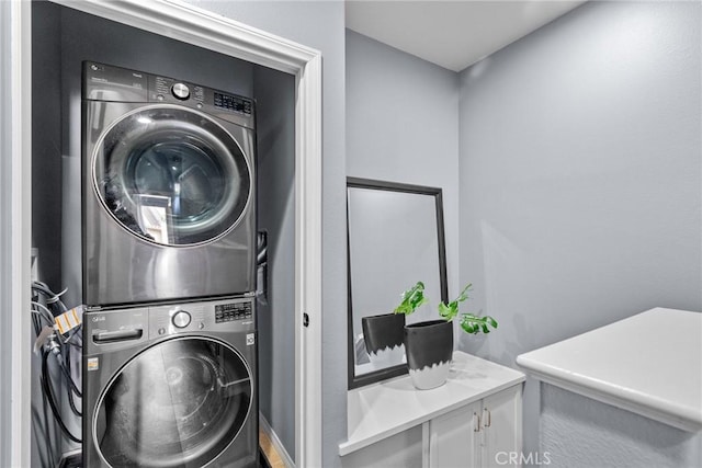 clothes washing area with stacked washer / dryer