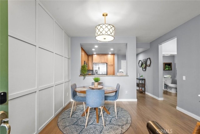 dining space with recessed lighting, wood finished floors, and baseboards