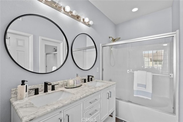 bathroom featuring double vanity, combined bath / shower with glass door, recessed lighting, and a sink