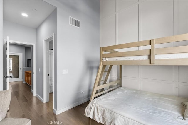 bedroom featuring visible vents, baseboards, and wood finished floors