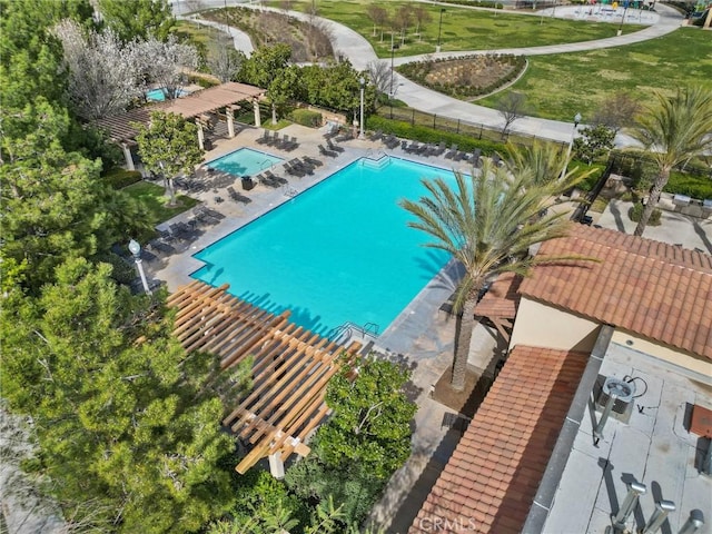 community pool with a patio and fence