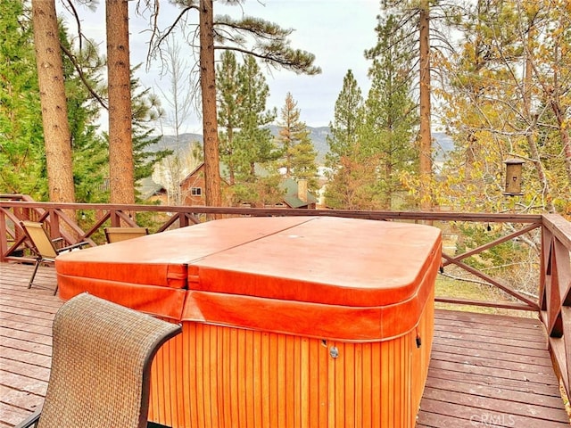 deck with a mountain view and a hot tub