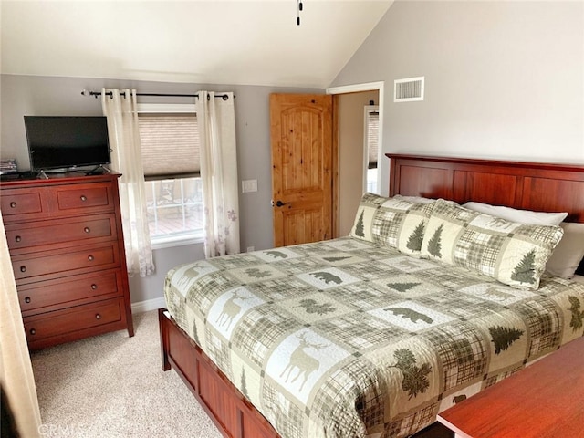 bedroom with vaulted ceiling, light colored carpet, visible vents, and baseboards